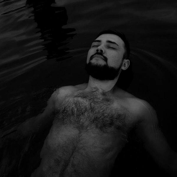 Person meditating peacefully in a calm environment with soft lighting.